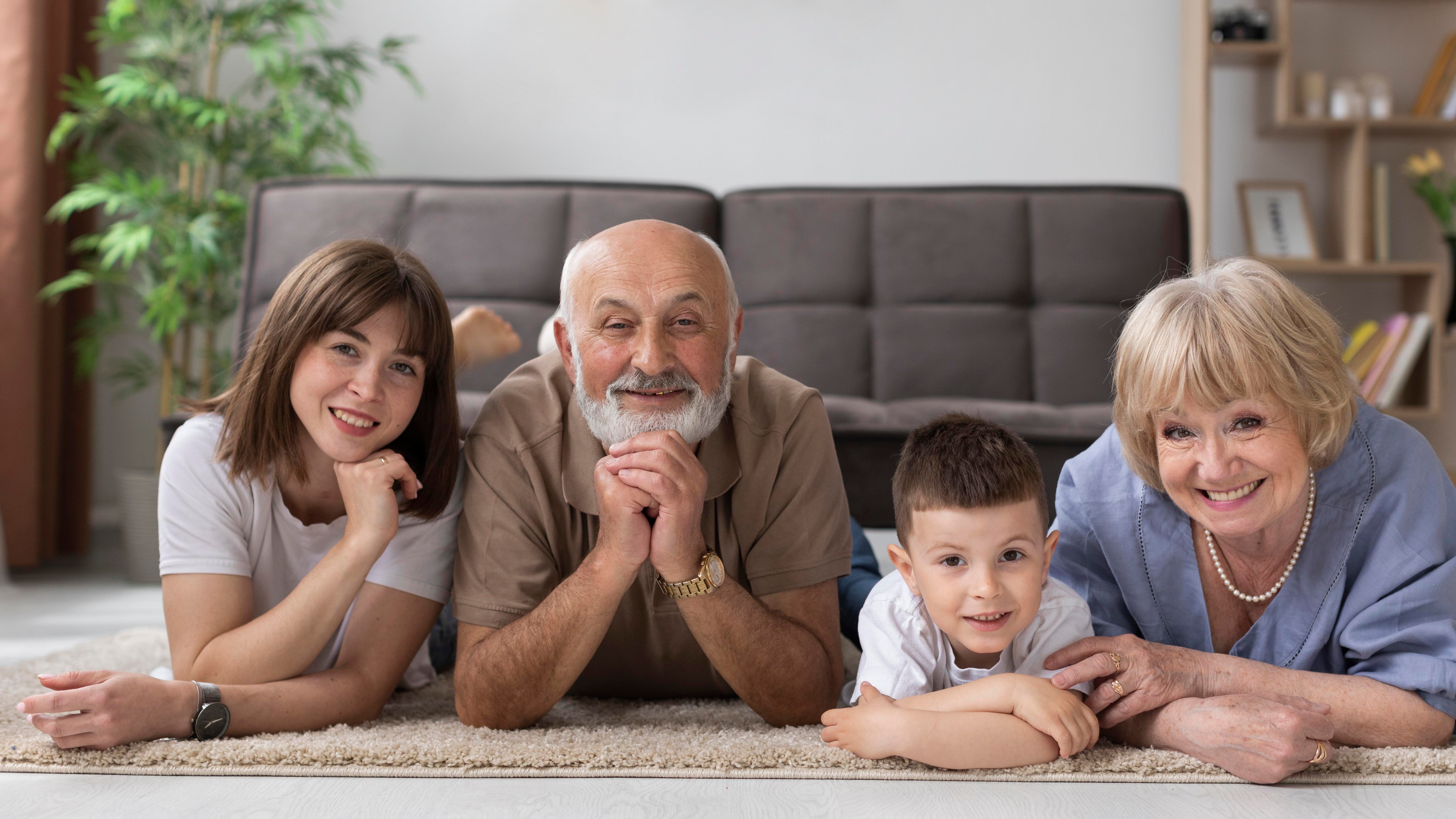 Elderly couple laying on the ground with their family
